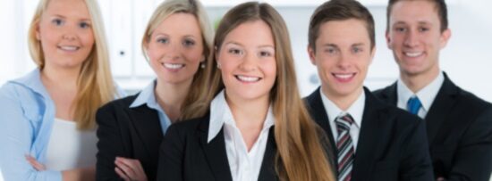 5 lachende Personen die schick angezogen sind