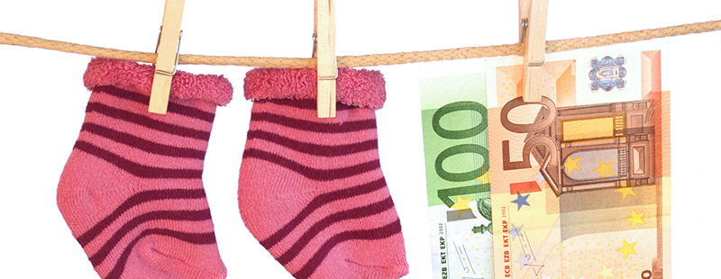 Ein Bild auf dem eine Schnur gespannt ist, an dieser Schnur hängen zwei rot gestreifte Baby socken und 2 Geld scheine