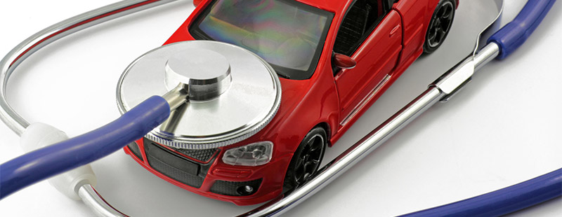 Ein Bild auf dem ein rotes Auto steht und ein Stethoskop auf der Motorhaube liegt