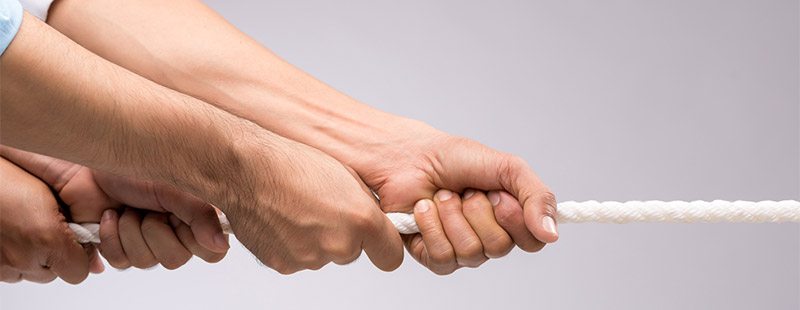 Ein Bild an dem mehrere Hände an einem Ende eines Seiles ziehen