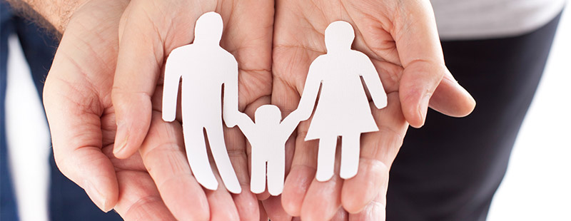 Ein Bild in dem 2 Hände offen aufeinander Liegen, in den Händen liegt eine Karikatur als eine Familie