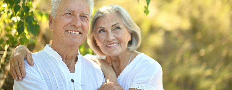 Rentner Ein Bild wo ein älteres Pärchen im Grünen sitzt und sich im Arm halten