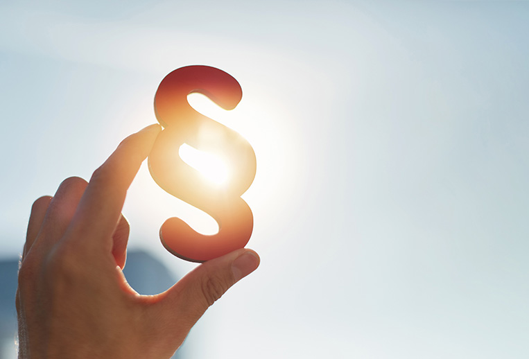 Eine Hand die das Gesetz - Zeichen in den Himmel hält